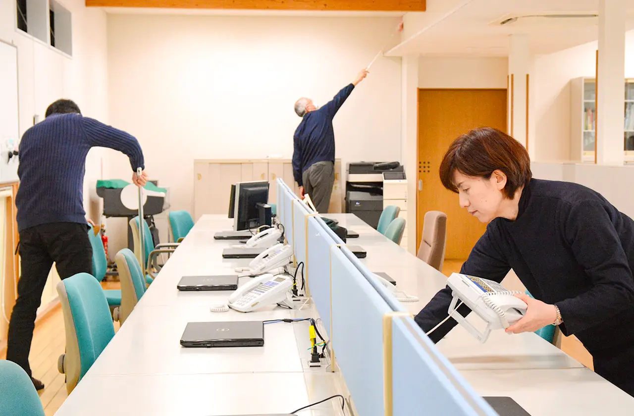 オフィスで清掃と整理整頓を行う社員