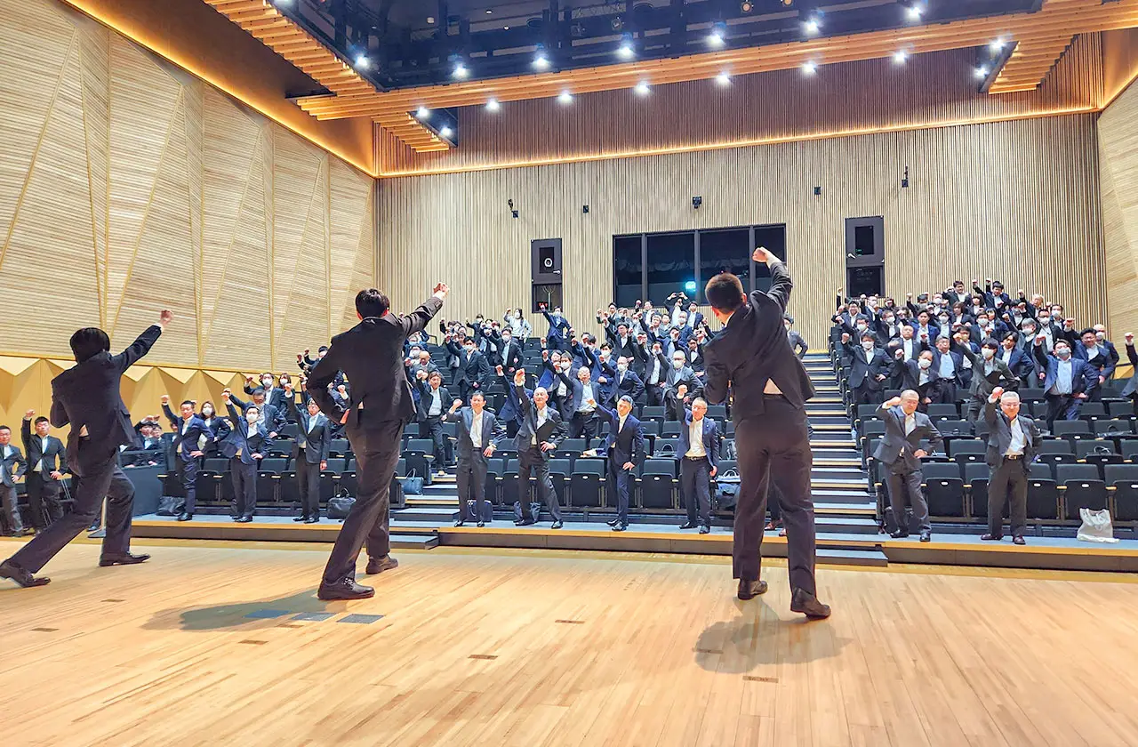 会場で一体となって気勢を上げる社員たち